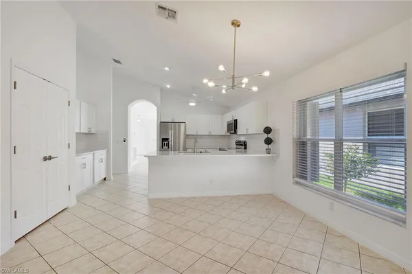a large white kitchen with a large window