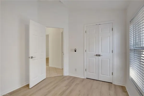 a view of an empty room with closet and a window