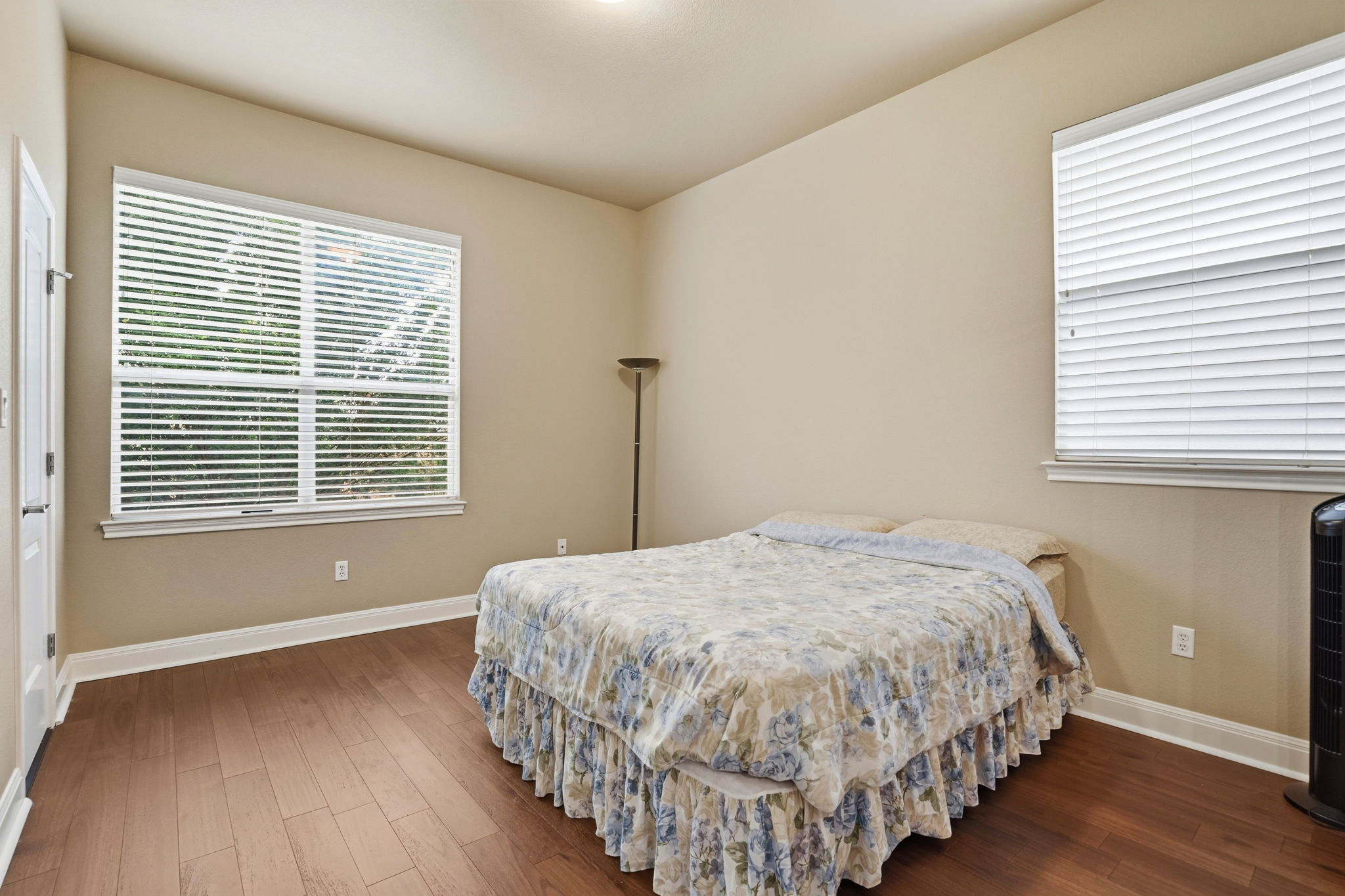 222 Vailco Lane Austin, TX 78738 - Photo 28 of 39 Room featuring two windows with horizontal blinds, wood-finish flooring, neutral wall paint, and white baseboards