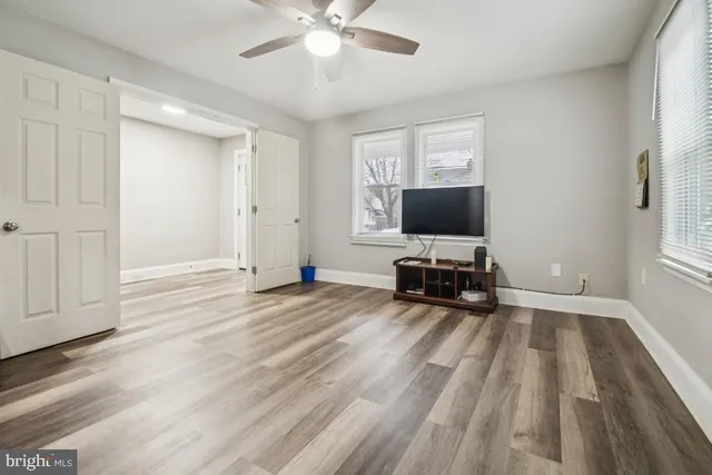 a view of room with wooden floor and flat screen tv