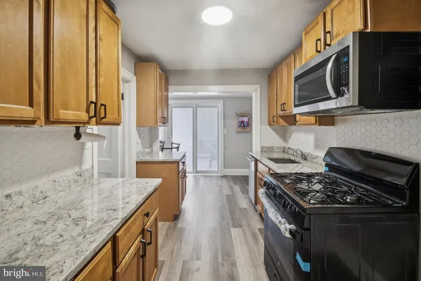 a kitchen with stainless steel appliances granite countertop a stove a sink and a microwave
