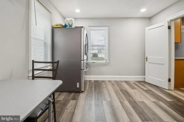 a view of a kitchen with wooden floor and a refrigerator