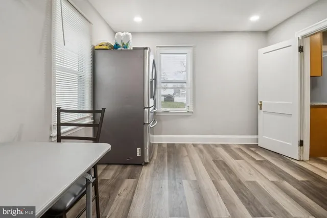 a view of a kitchen with wooden floor and a refrigerator