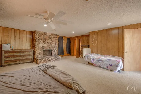 a spacious bedroom with a large bed a chandelier and closet
