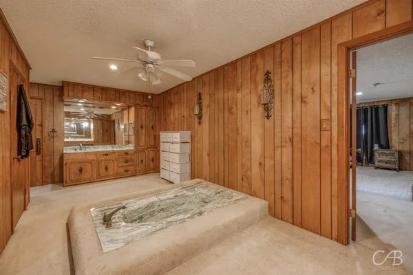 a spacious bedroom with a large bed a chandelier and closet