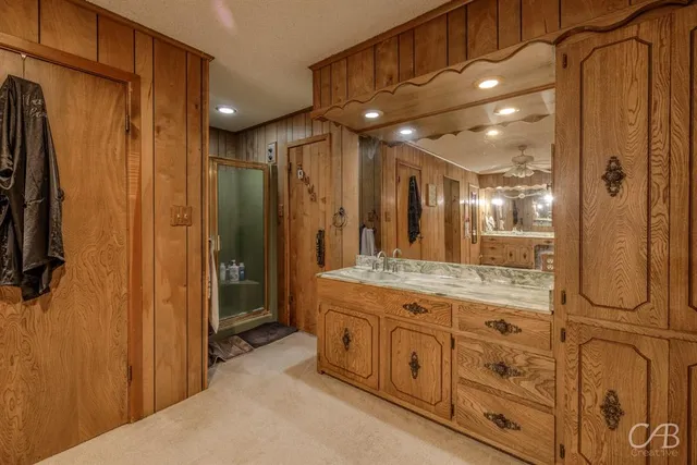 a bathroom with a granite countertop sink a toilet and shower