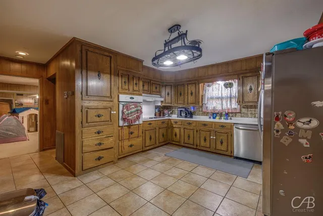 a kitchen with stainless steel appliances granite countertop a refrigerator and a sink