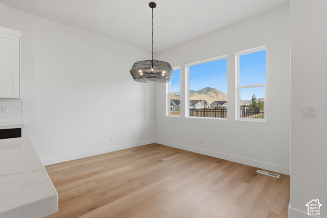 538 North Legend Circle, Unit 505 Mapleton, UT 84664 - Photo 22 of 48 Light wood-finish flooring, multiple windows, contemporary pendant lighting, white walls, and a white quartz countertop