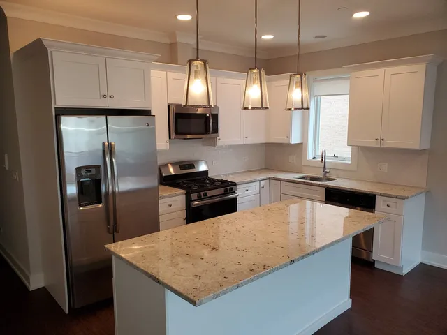 a kitchen with stainless steel appliances granite countertop a sink a stove and refrigerator