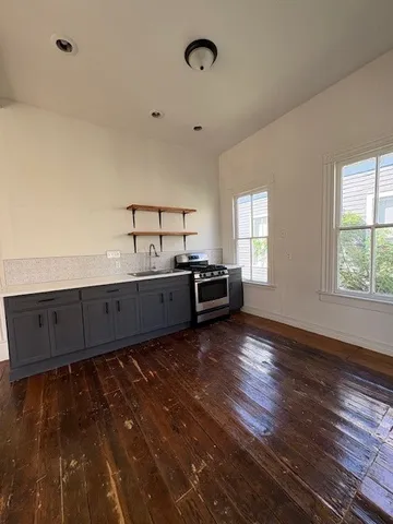 a view of a kitchen with cabinets wooden floor and window