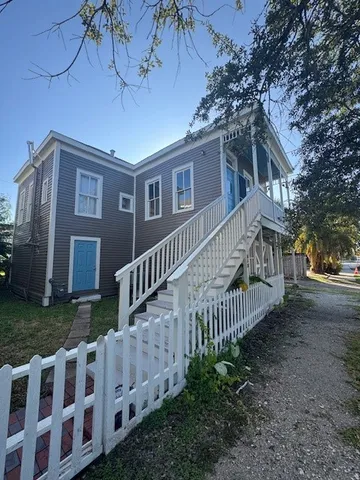 a view of a house with wooden deck and a yard