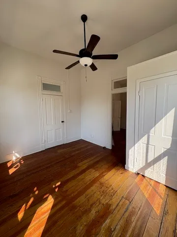 a view of empty room with wooden floor