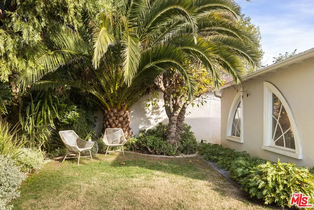 a backyard of a house with table and chairs