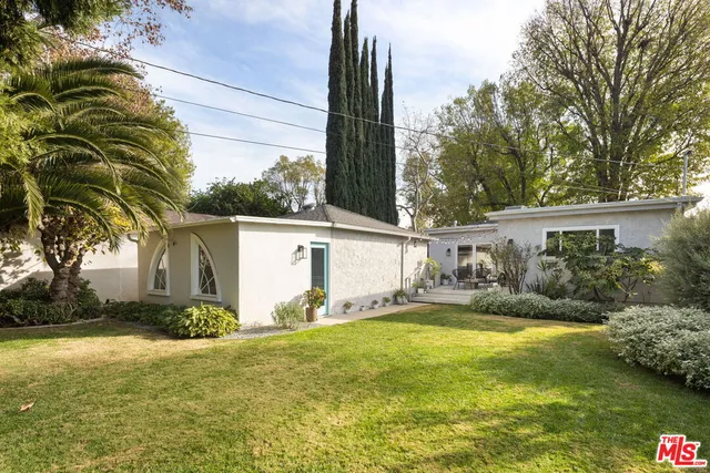 a view of a house with a yard and palm trees
