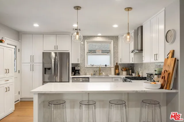 a kitchen with kitchen island a sink stainless steel appliances and cabinets