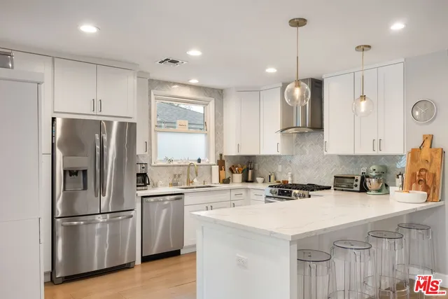 a kitchen with kitchen island a white cabinets and refrigerator