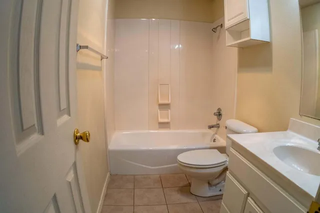 a bathroom with a granite countertop toilet a sink and a bathtub