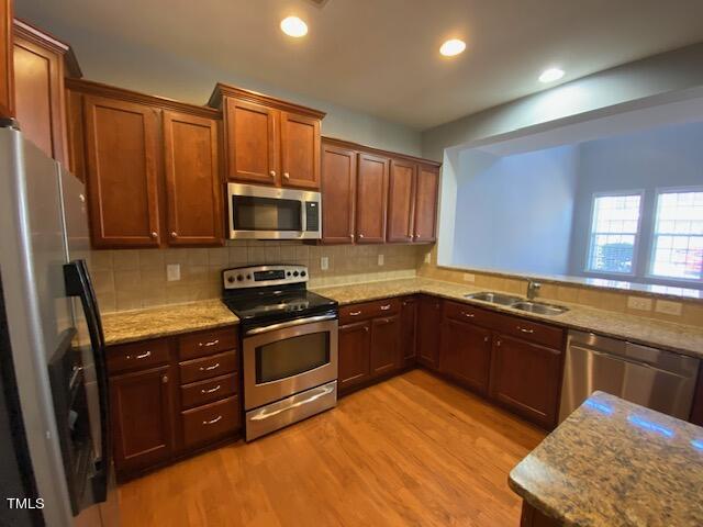 10103 Falls Meadow Court Raleigh, NC 27617 - Photo 29 of 54 a kitchen with stainless steel appliances granite countertop wooden cabinets a stove top oven a sink and dishwasher