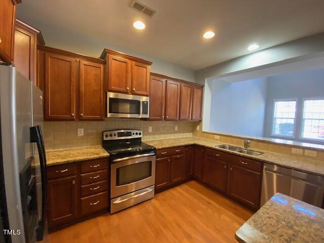 10103 Falls Meadow Court Raleigh, NC 27617 - Photo 30 of 54 a kitchen with stainless steel appliances granite countertop wooden cabinets a stove top oven a sink and dishwasher