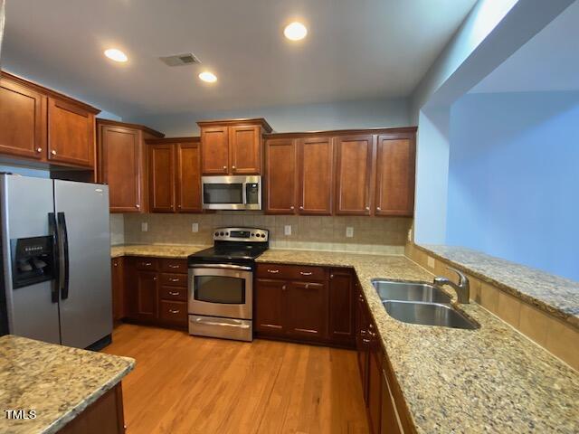 10103 Falls Meadow Court Raleigh, NC 27617 - Photo 8 of 54 a kitchen with wooden cabinets sink and stainless steel appliances