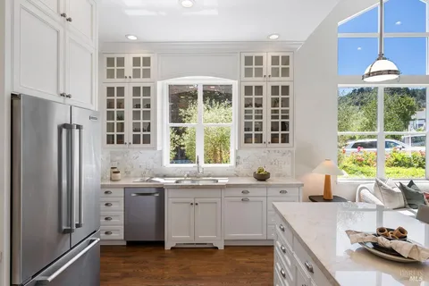 a kitchen with stainless steel appliances a sink a stove and a window