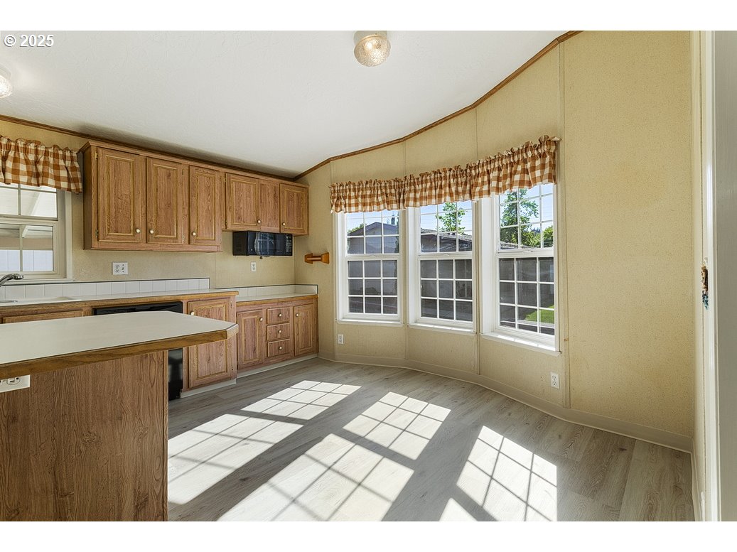 1949 Southeast Palmquist Road, Unit 100 Gresham, OR 97080 - Photo 12 of 28 a kitchen with a window a sink and a counter top space