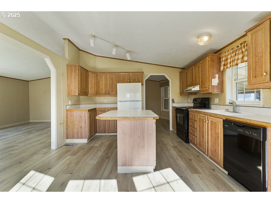 1949 Southeast Palmquist Road, Unit 100 Gresham, OR 97080 - Photo 14 of 28 a kitchen with granite countertop a stove a sink and a refrigerator