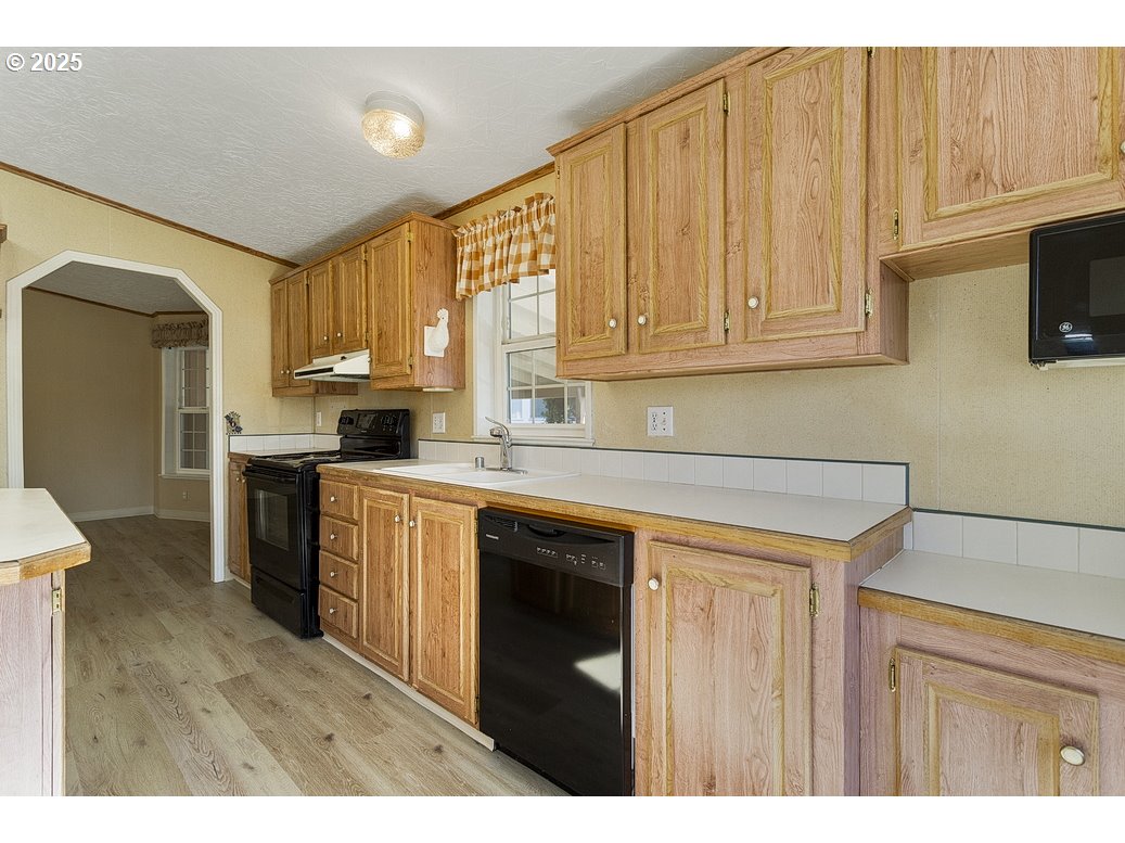 1949 Southeast Palmquist Road, Unit 100 Gresham, OR 97080 - Photo 15 of 28 a kitchen with granite countertop a sink cabinets stainless steel appliances and a window