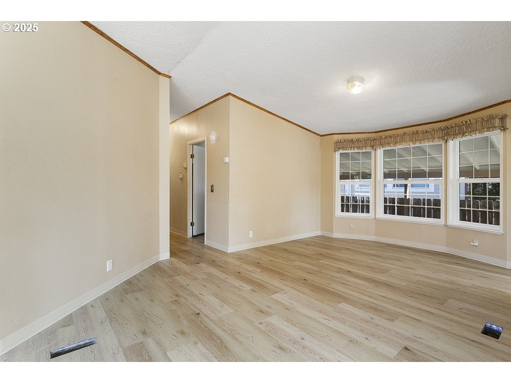 1949 Southeast Palmquist Road, Unit 100 Gresham, OR 97080 - Photo 16 of 28 a view of an empty room with wooden floor and a window