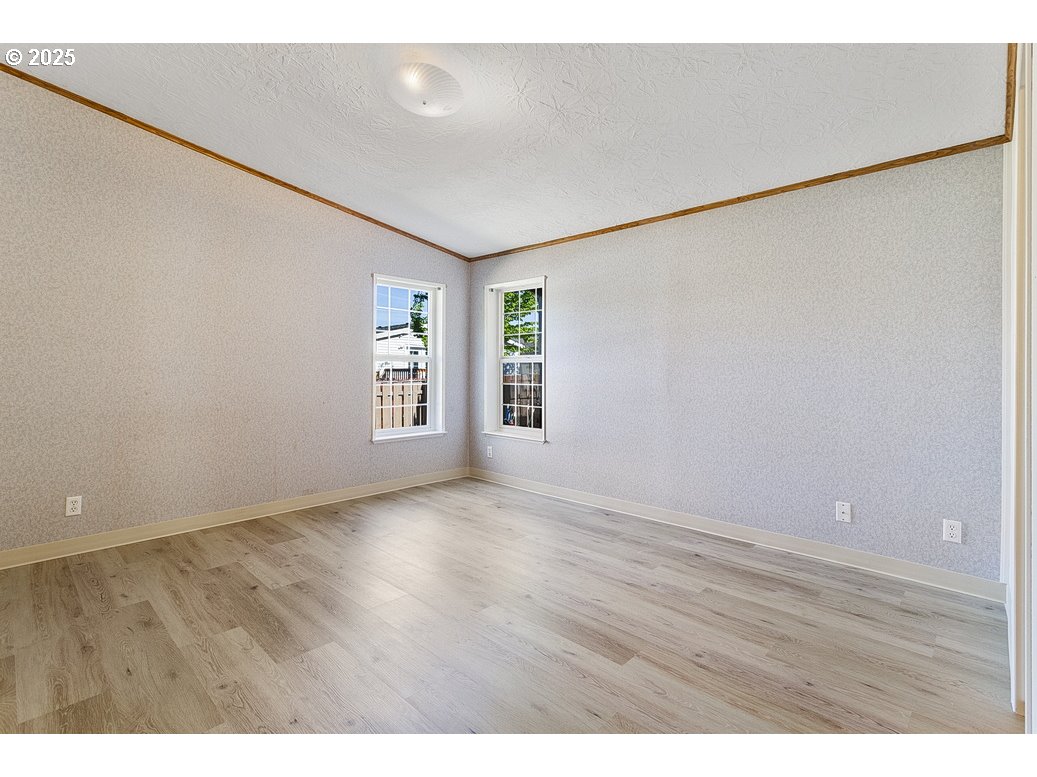 1949 Southeast Palmquist Road, Unit 100 Gresham, OR 97080 - Photo 20 of 28 a view of an empty room with wooden floor and a window