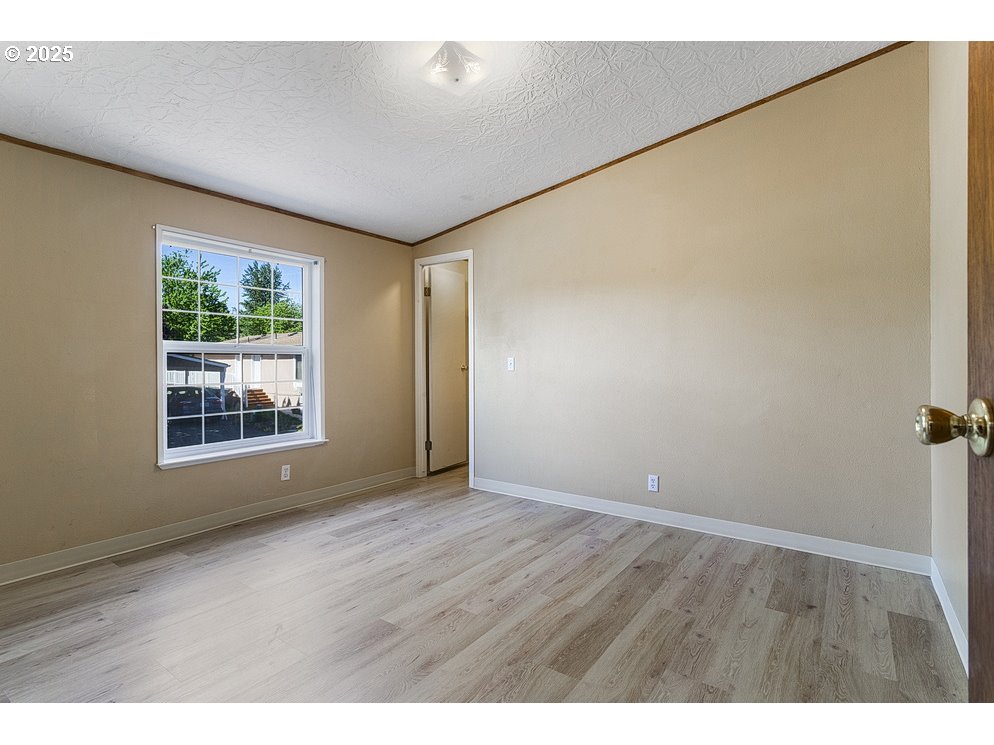 1949 Southeast Palmquist Road, Unit 100 Gresham, OR 97080 - Photo 24 of 28 a view of an empty room with wooden floor and a window