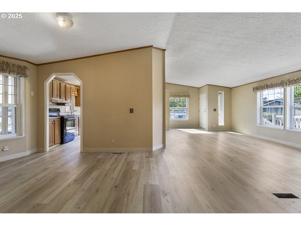 1949 Southeast Palmquist Road, Unit 100 Gresham, OR 97080 - Photo 9 of 28 a view of an empty room with window and wooden floor
