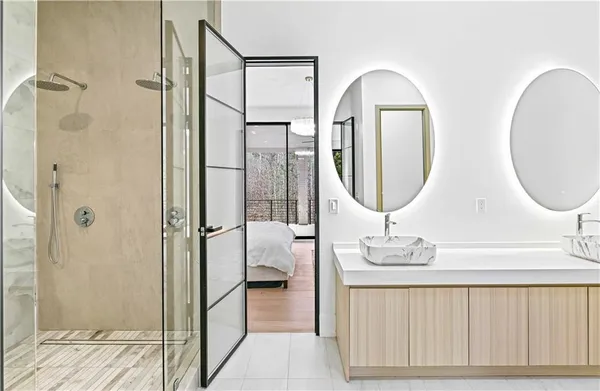 a bathroom with a double vanity sink mirror and shower