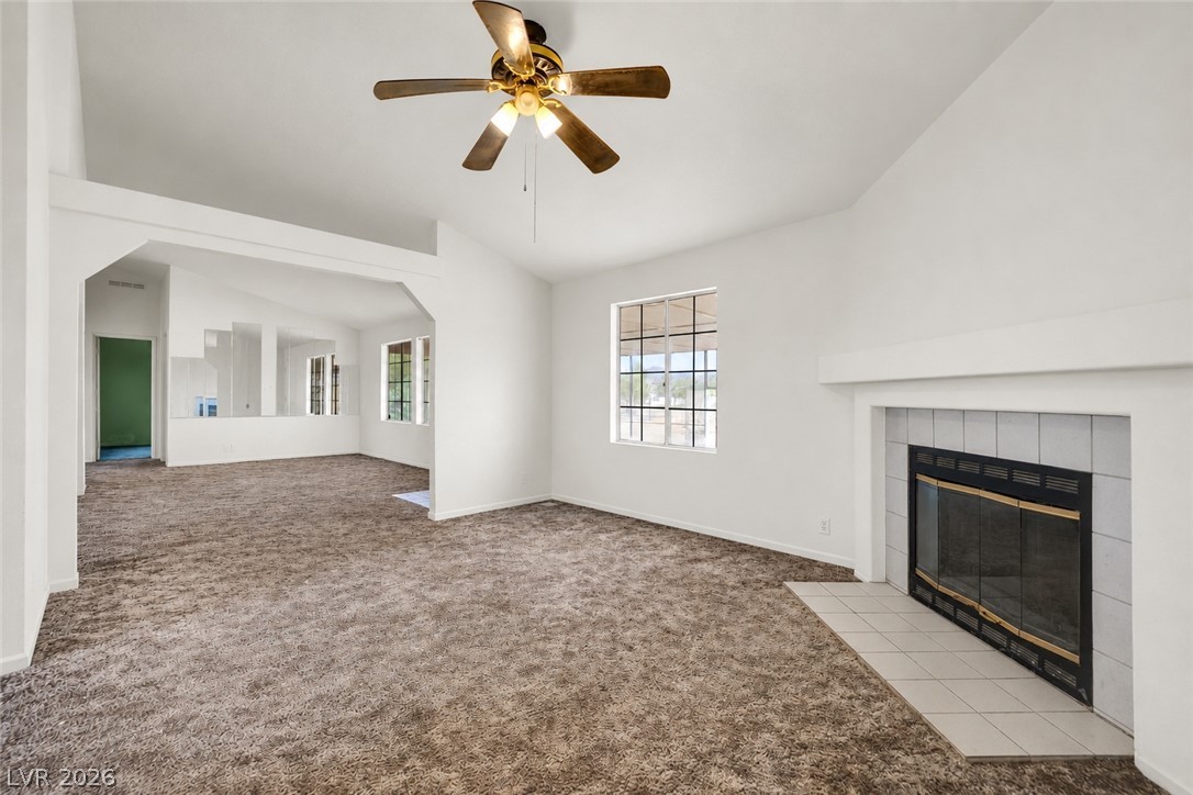 4361 Maple Road Pahrump, NV 89048 - Photo 14 of 35 A welcoming living area with vaulted ceilings and a cozy fireplace, perfect for relaxation.