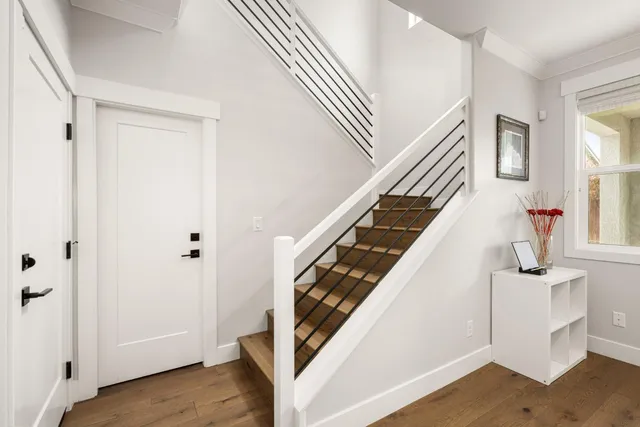 a view of a house with a yard plants and large tree
