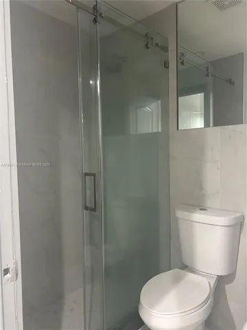 a white toilet sitting next to a bathroom sink