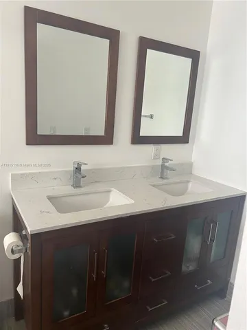 a bathroom with a double vanity sink and a mirror