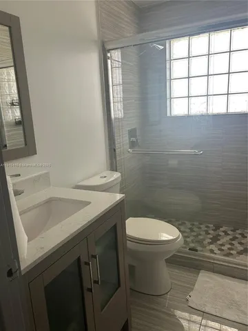 a bathroom with a sink a toilet and a window