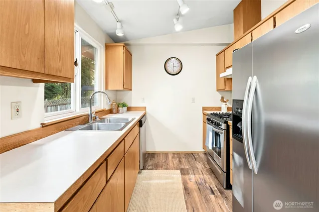 a kitchen with kitchen island granite countertop a sink appliances cabinets and a counter top space