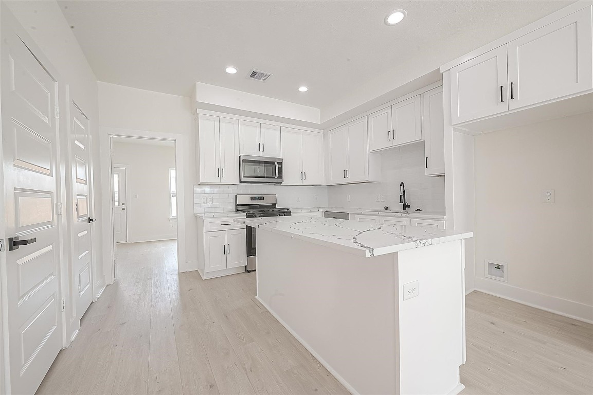 4135 Mallow Street, Unit B Houston, TX 77051 - Photo 7 of 11 a kitchen with white cabinets and white appliances