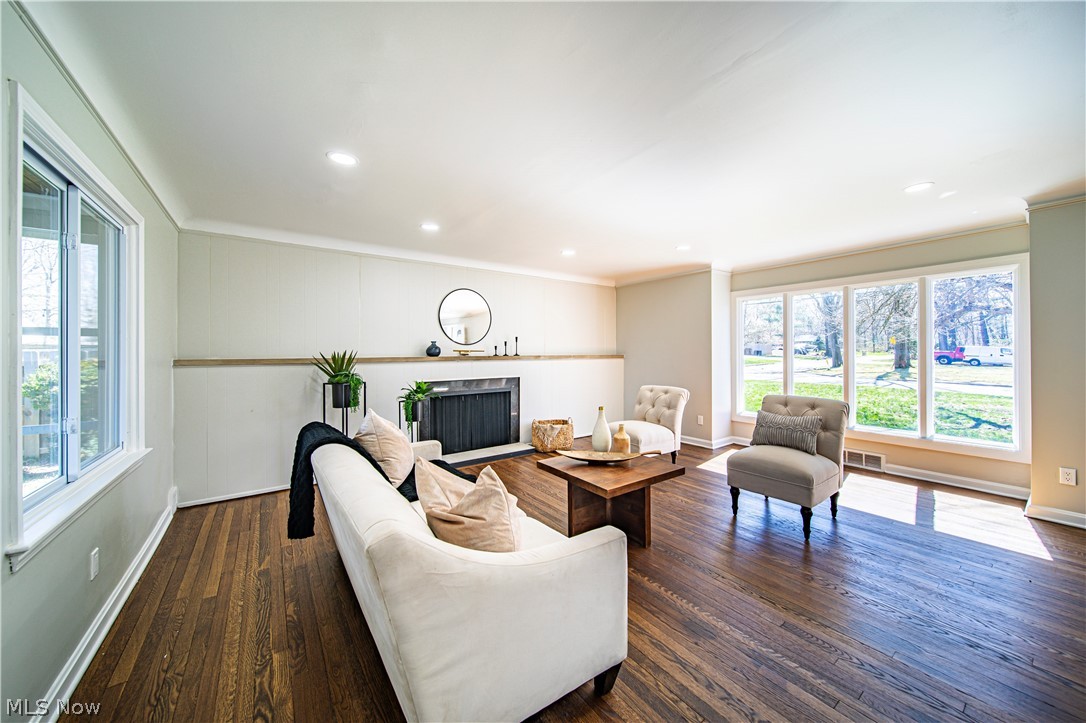 Living room featuring dark wood-type flooring and crown molding