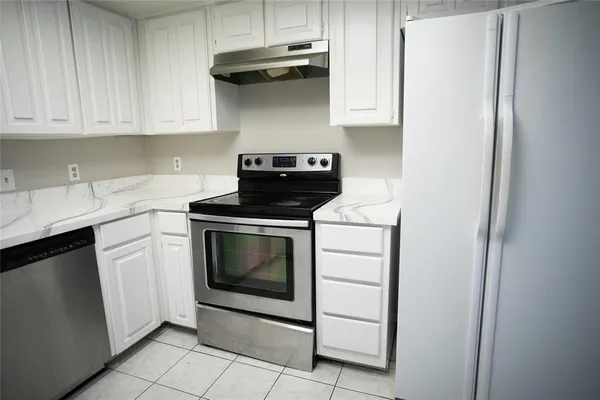 a kitchen with stainless steel appliances granite countertop a stove a refrigerator and cabinets