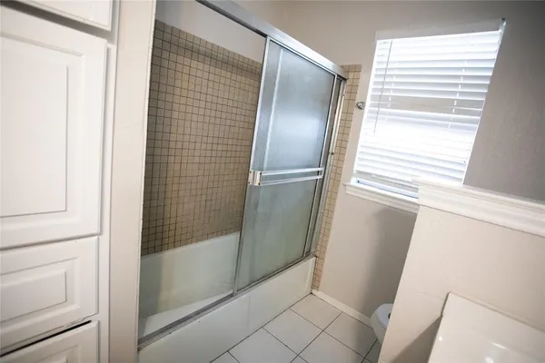 a bathroom with a glass door shower and a sink