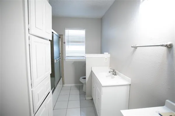 a bathroom with a sink a toilet and a window
