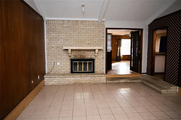 an empty room with fireplace and windows