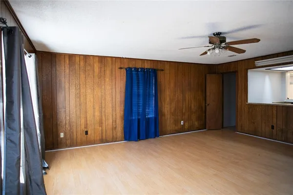 an empty room with windows and fan