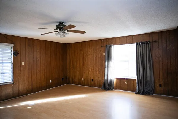 an empty room with windows and cabinet