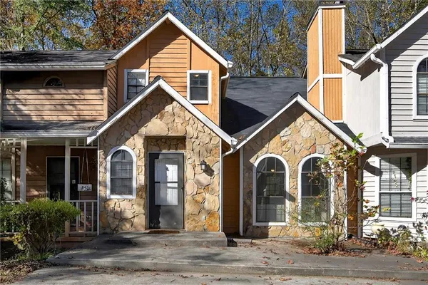 a view of a house with brick walls and cars parked