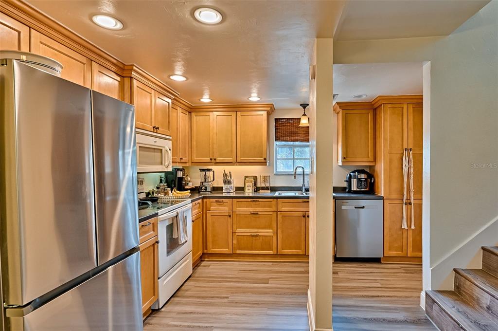 2338 Southwest 73rd Terrace Gainesville, FL 32607 - Photo 7 of 29 a kitchen with stainless steel appliances granite countertop a refrigerator a stove and a wooden floors