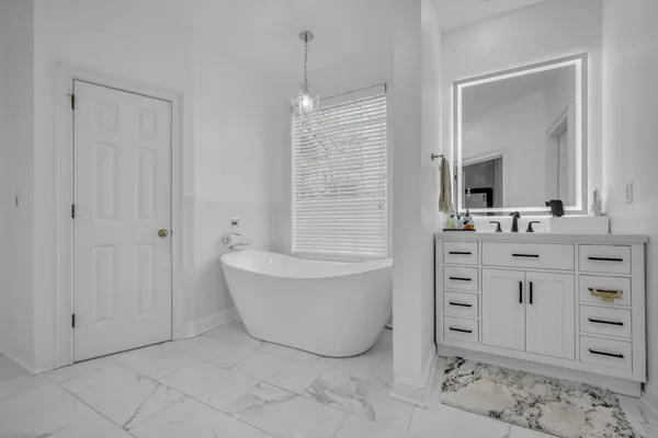 a bathroom with a bathtub sink and mirror